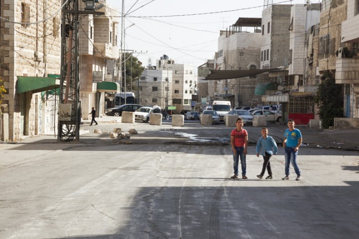 Ahlam Shibli, Untitled (Occupation no. 30), al-Khalil, Palestine, 2016–17, chromogenic print, 100 x 150 cm. Al-Sahleh Street, al-Qaitoun neighborhood, Old Town, al-Khalil, October 20, 2016. The Abu al-Rish checkpoint located in al-Sahleh Street, south of al-Haram al-Ibrahimi (Abraham’s Mosque/Cave of the Patriarchs), is named after the Abu al-Rish mosque and shrine next to it. The checkpoint separates the Abu Sunaina and al-Qaitoun neighborhoods from the neighborhoods of the Old Town. It also separates the neighborhood from the oldest school in al-Khalil, the al-Ibrahimeyeh School, and from al-Hajariya Girls School. Palestinians are allowed to pass only on foot. The infrastructure of the checkpoint was expanded in July 2016, and since it reopened the Israeli Defense Forces (IDF) have prohibited Palestinians between the ages of sixteen and thirty-four from passing. Courtesy of the artist, © Ahlam Shibli